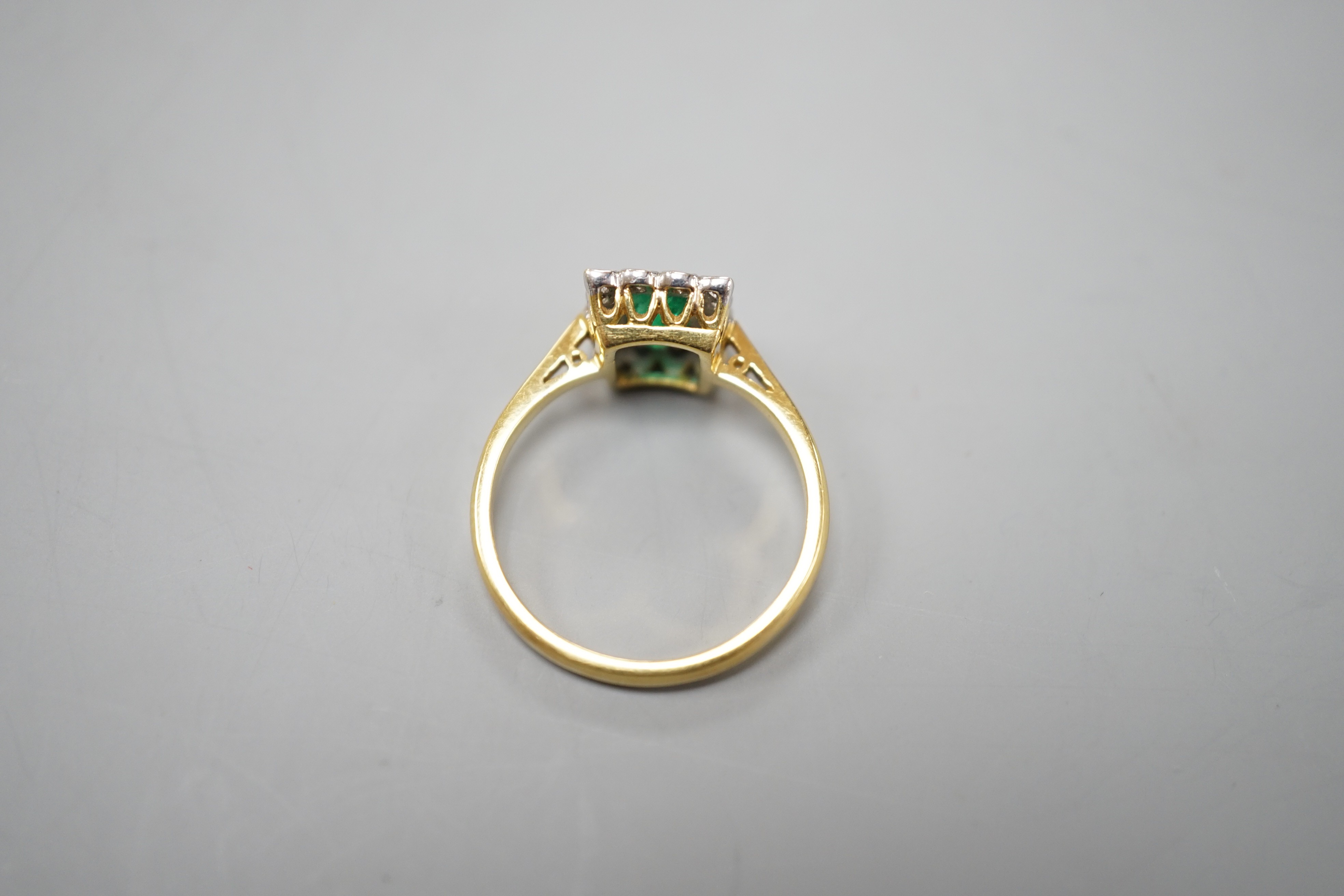 A modern 18ct gold, emerald and diamond set rectangular cluster ring, size N, gross weight 3.4 grams